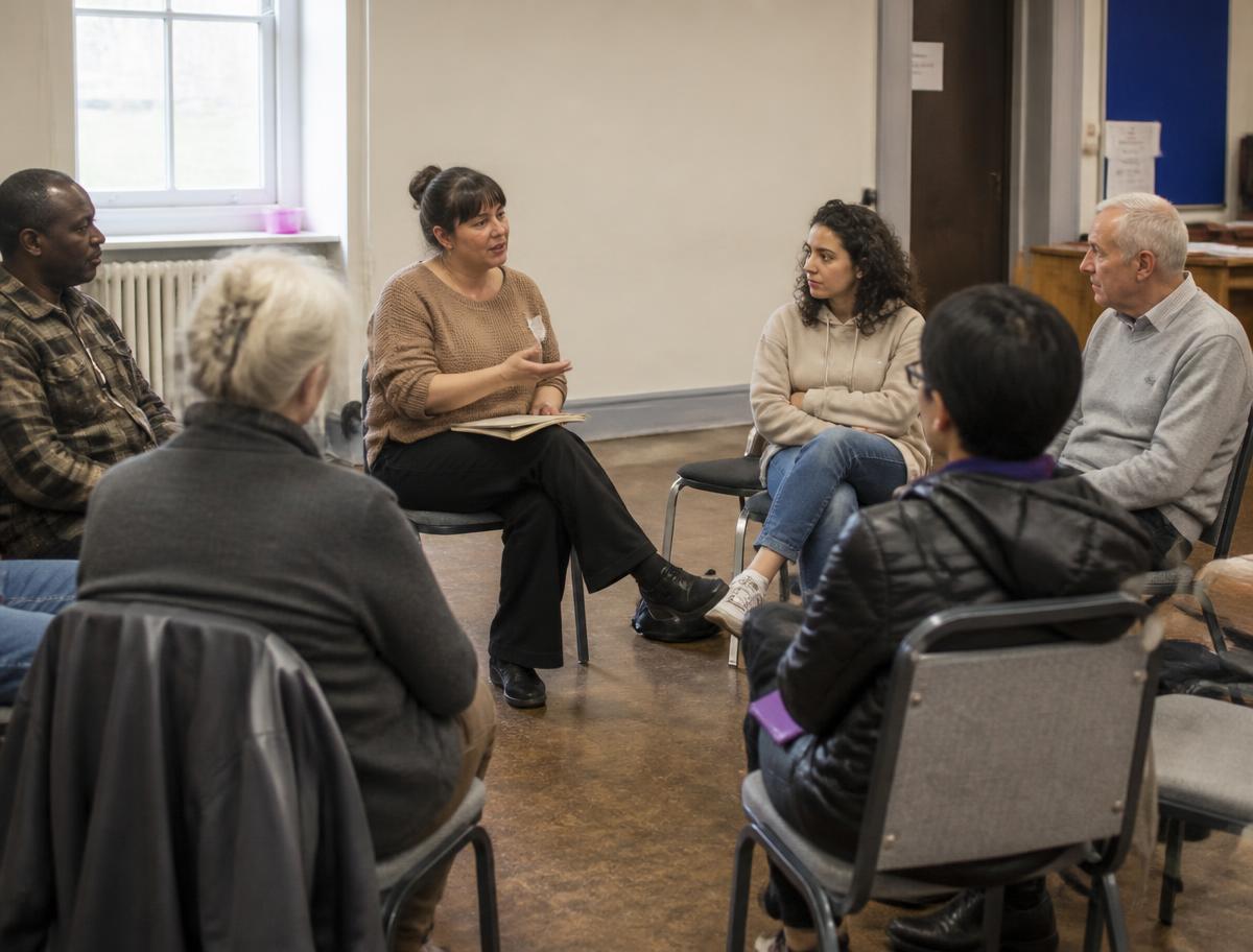 Adults of varied ages seated together during a community learning session